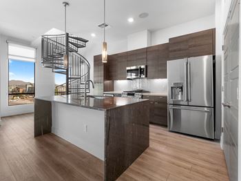 a large kitchen with stainless steel appliances and a spiral staircase at Scottsdale Grand, Scottsdale
